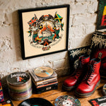 Lade das Bild in den Galerie-Viewer, a collection of various items, including a framed artwork, CDs, boots, and other miscellaneous objects, all displayed on a wooden surface against a white brick wall.

