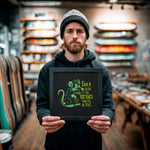 Load image into Gallery viewer, A man in a black hoodie holds up a framed image with a green and black design of a rat.
