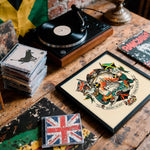 Lade das Bild in den Galerie-Viewer, a collection of various items, including a record player, a framed picture, a stack of CDs, and a flag, all arranged on a wooden surface.
