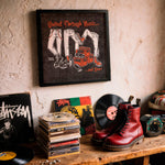 Lade das Bild in den Galerie-Viewer, a collection of music-related items, including a framed poster, a stack of CDs, a pair of red boots, and various other items such as a record player and a camera.
