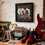 Lade das Bild in den Galerie-Viewer, a collection of music-related items, including a framed poster, a stack of CDs, a pair of red boots, and a red electric guitar, all set against a white wall.
