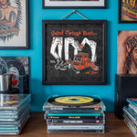 Lade das Bild in den Galerie-Viewer, a wall with a framed poster that says "United Through Music..." and "And Beer!" above illustrations of a person wearing jeans and a shoe, along with a record player and a stack of CDs.
